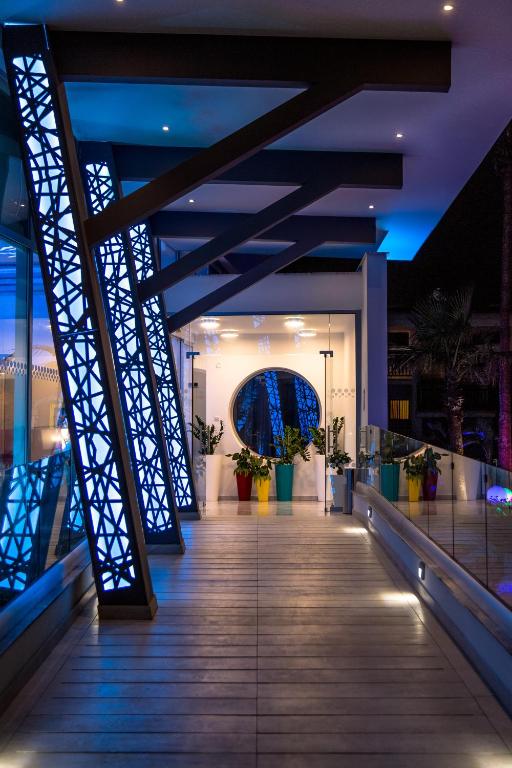 a walkway in a building with blue lights at Nicholas Color Hotel in Ayia Napa