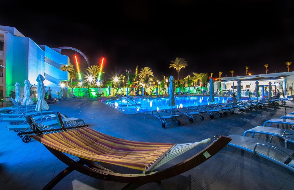 a resort with a hammock and a water park at night at Nicholas Color Hotel in Ayia Napa