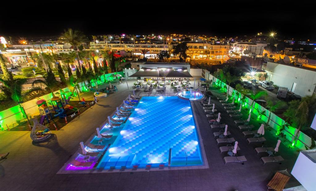 una vista panoramica su una piscina di notte di Nicholas Color Hotel a Ayia Napa