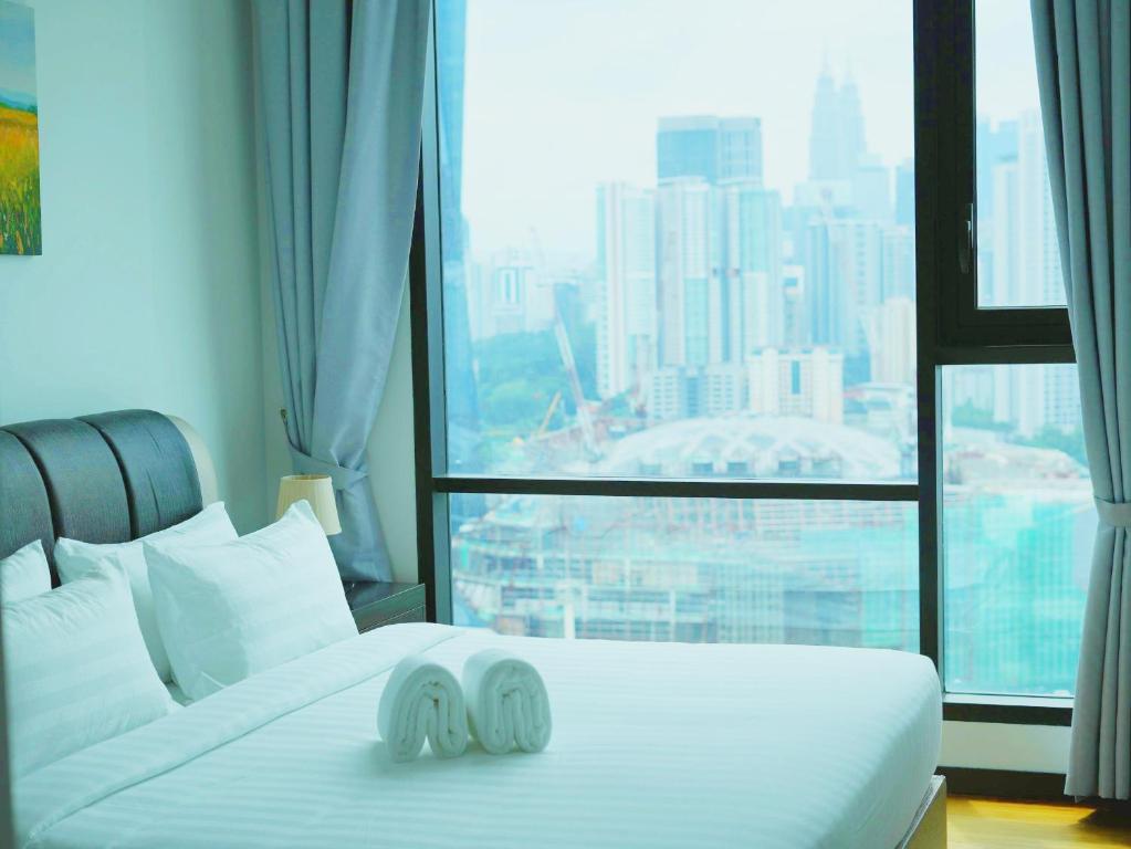a hotel room with a bed and a large window at Opus Residences by Ardent Homes in Kuala Lumpur