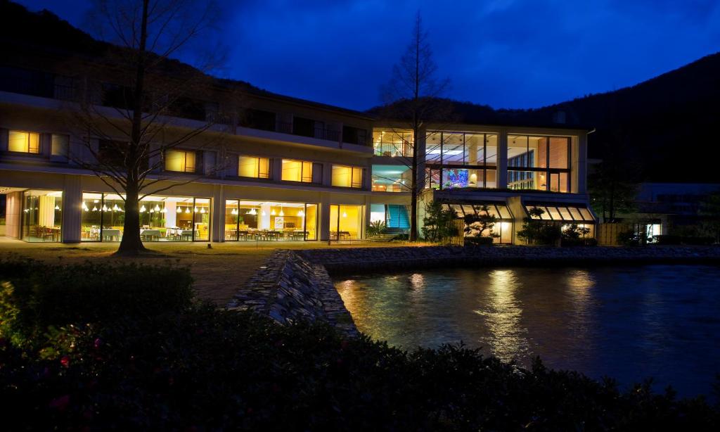 a building with a pond in front of it at night at Suigekka in Wakasa