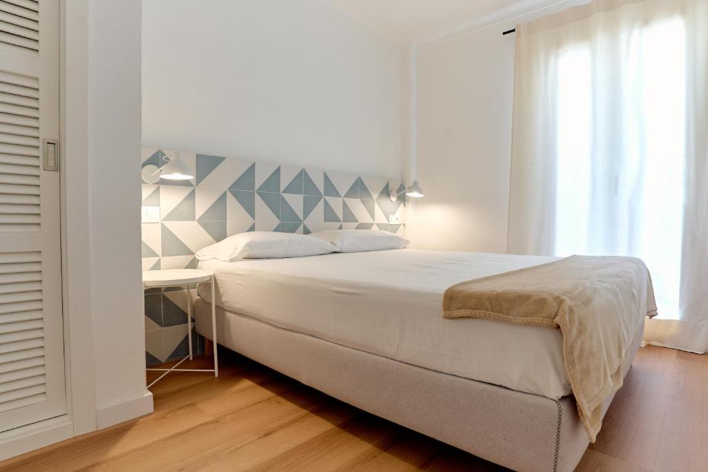 a bedroom with a large bed and a desk at Lavendel Apartments in Colonia Sant Jordi