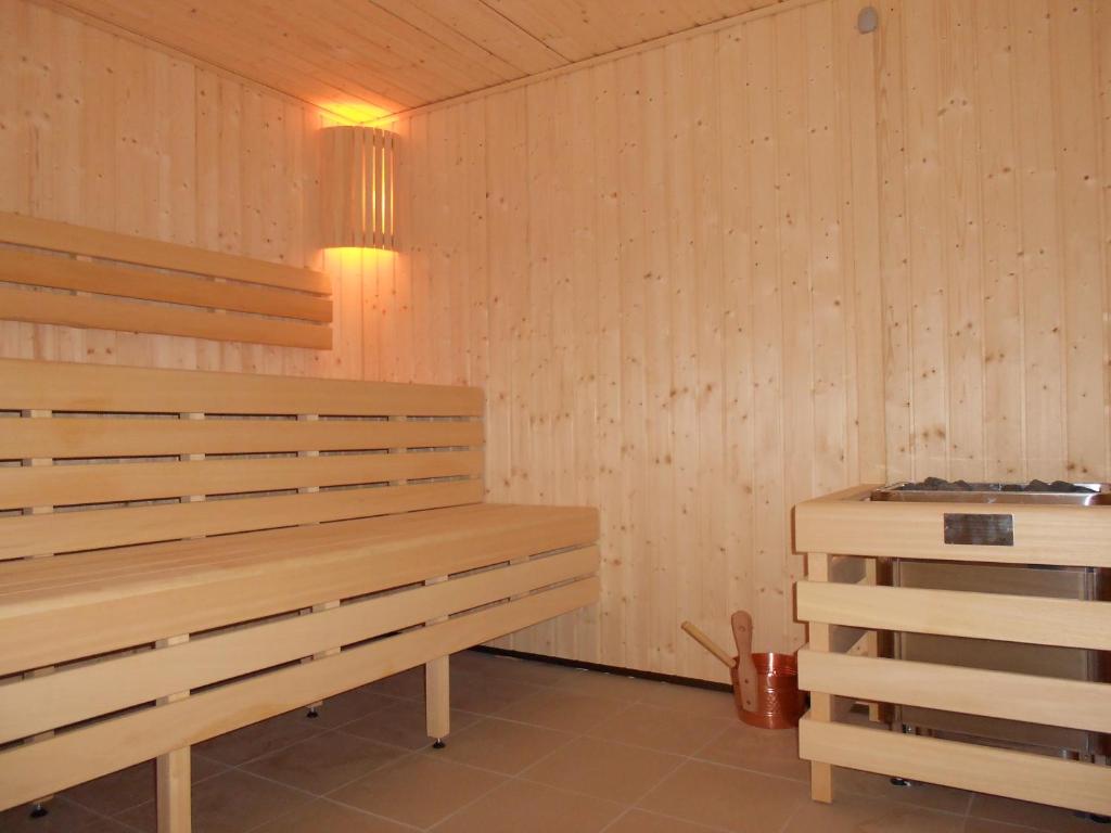a sauna with a wooden bench in a room at Hotel et Spa Les Cleunes Oléron in Saint-Trojan-les-Bains