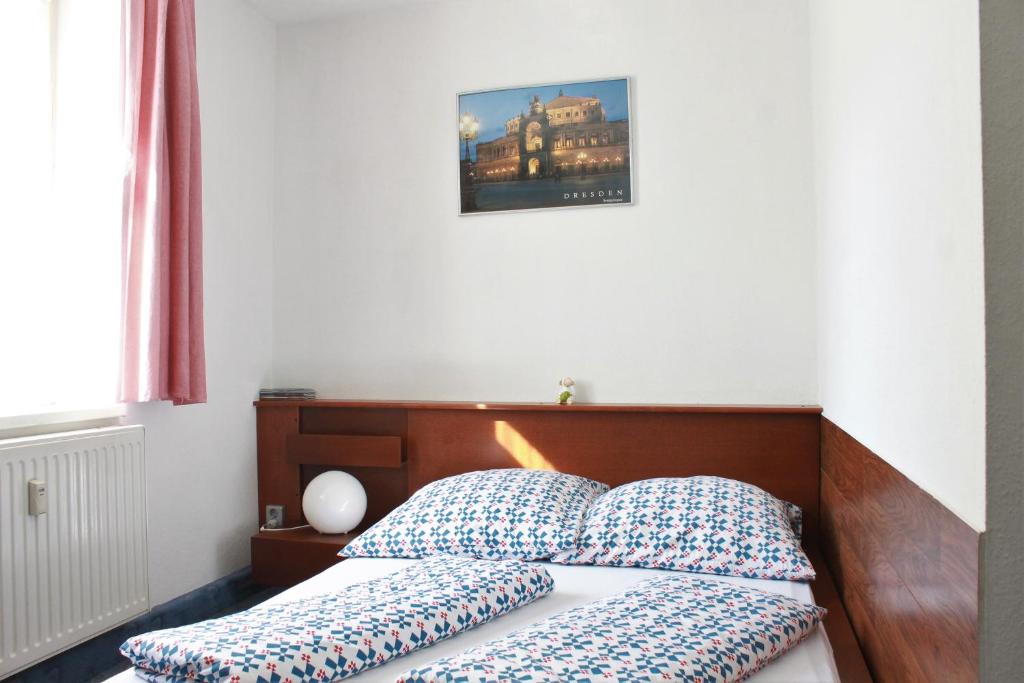 a bed with two pillows on it in a bedroom at Pension Pieschen Dresden in Dresden