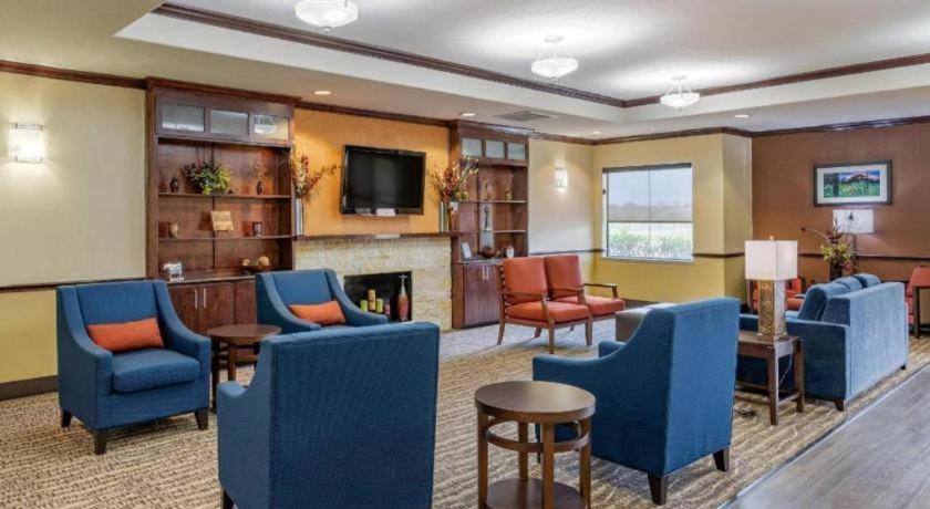 sala de estar con sillas azules y chimenea en Comfort Inn & Suites, en Navasota