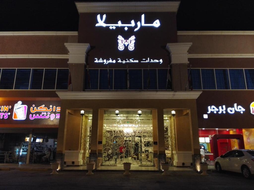 uma loja com uma placa na frente à noite em Marbella Residential Units em Riyadh