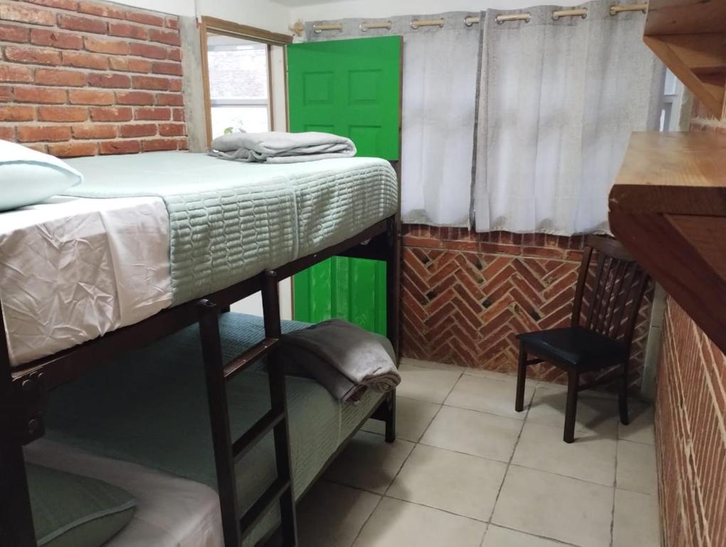 a room with two bunk beds and a green door at Xaltepic tú casa in Amecameca de Juárez