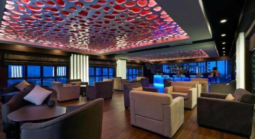 a restaurant with a bar with chairs and tables at Centrestage Petaling Jaya in Kuala Lumpur