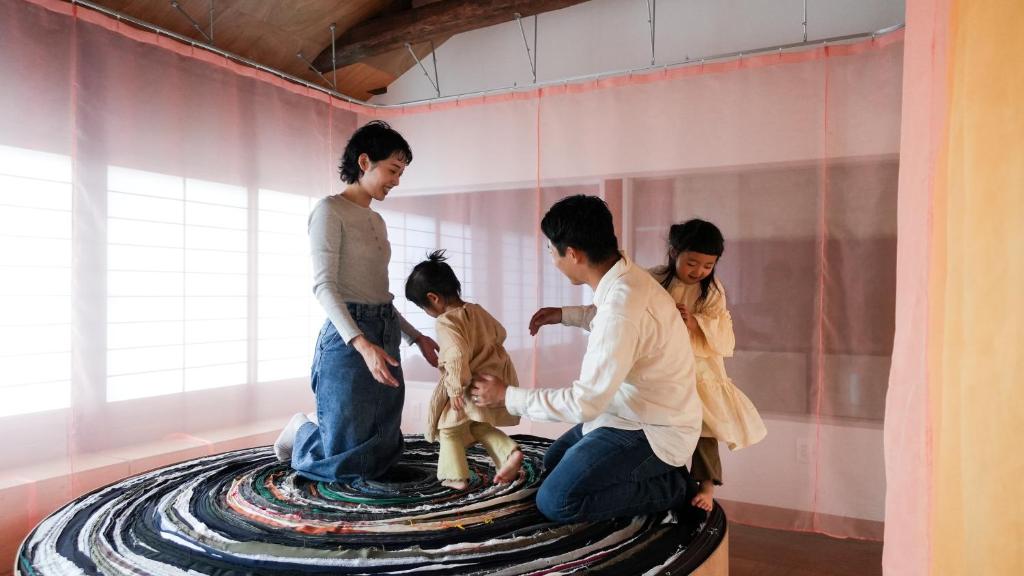 a group of people standing around a statue of a child at SEW STAY Soft Seam KYOTO MAIZURU in Maizuru