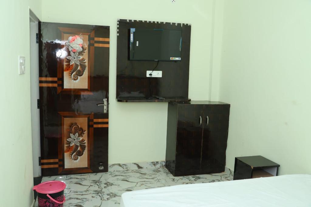 a room with a television and a door with a floor at Hotel Avtar Palace in Jāmb