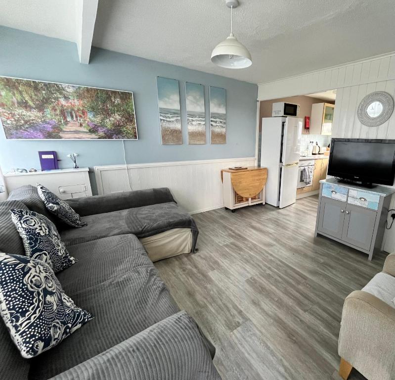a living room with a couch and a kitchen at California Beach Chalet in Great Yarmouth