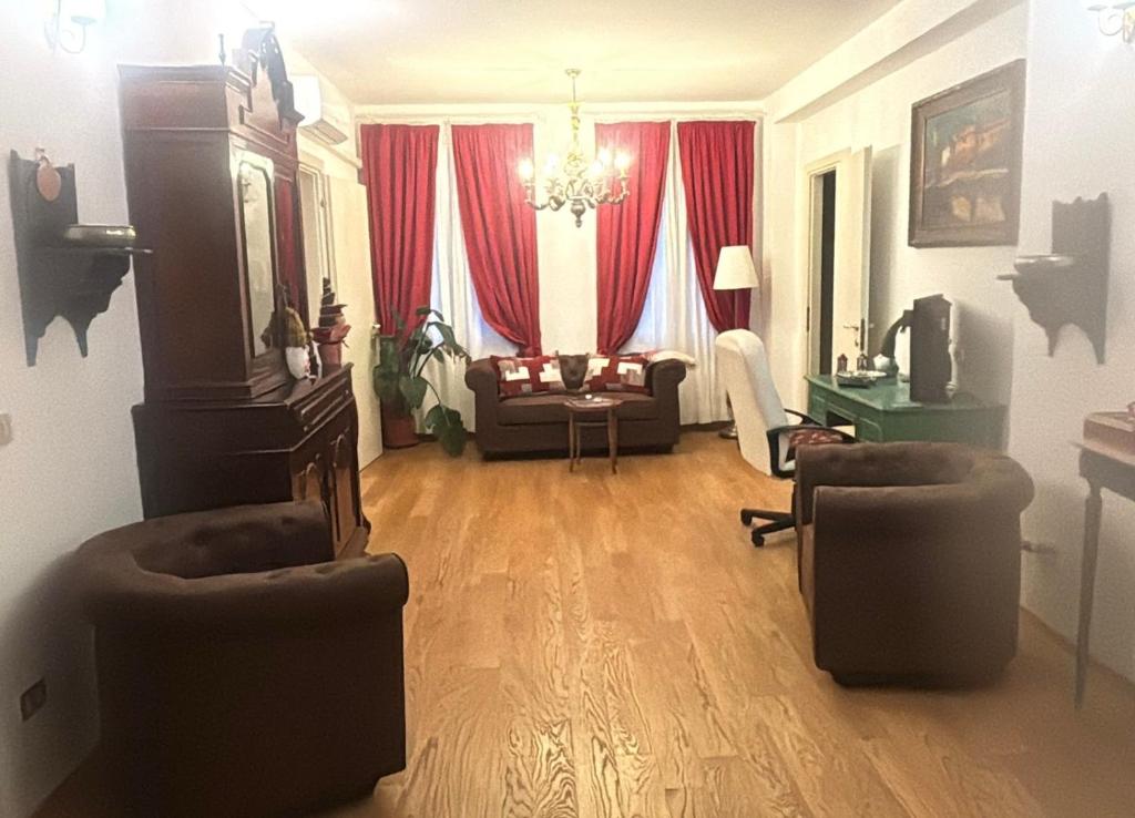 a living room with a couch and red curtains at Casa Bastianello favolosa vista sul Canale Vena in Chioggia