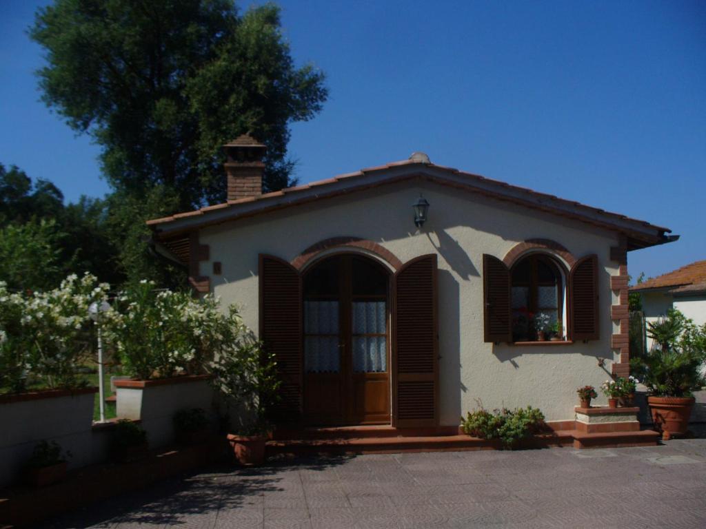 a small white house with brown shutters on it at Villetta in Maremma in La Pescaia