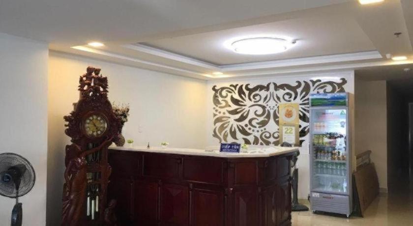 a room with a counter with a clock and a refrigerator at Phuong Ly Ly in Ho Chi Minh City
