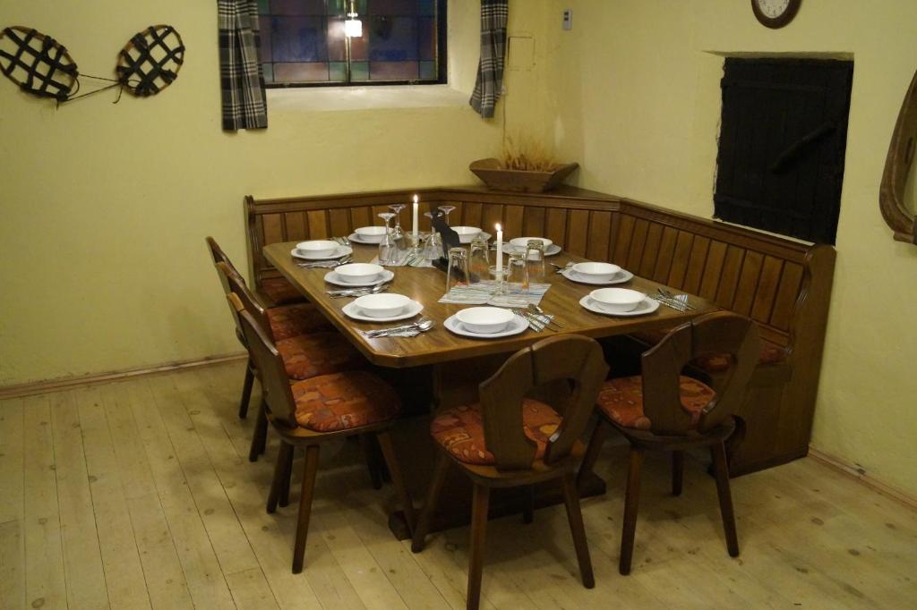 un tavolo in legno con sedie, piatti e bicchieri di Myrkulla Lodge a Jerfojaur
