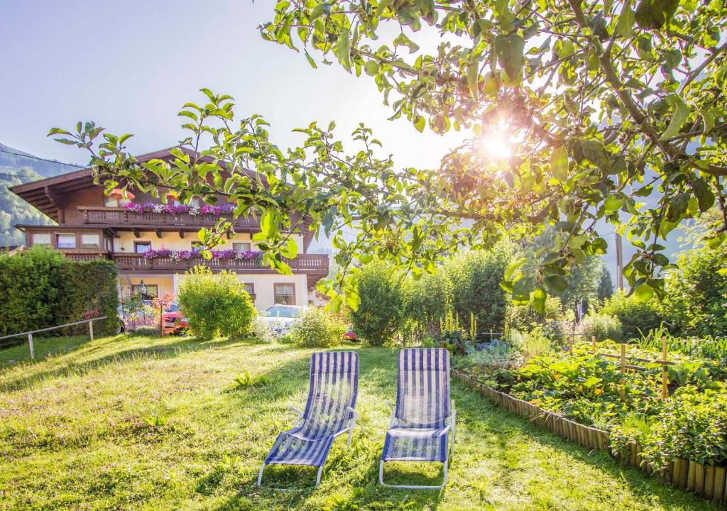 dos sillas azules sentadas en el patio de una casa en am mühlbach - einfach sein mit Gemeinschaftsküche und freien Eintritt in das Solarbad Dorfgastein, en Dorfgastein