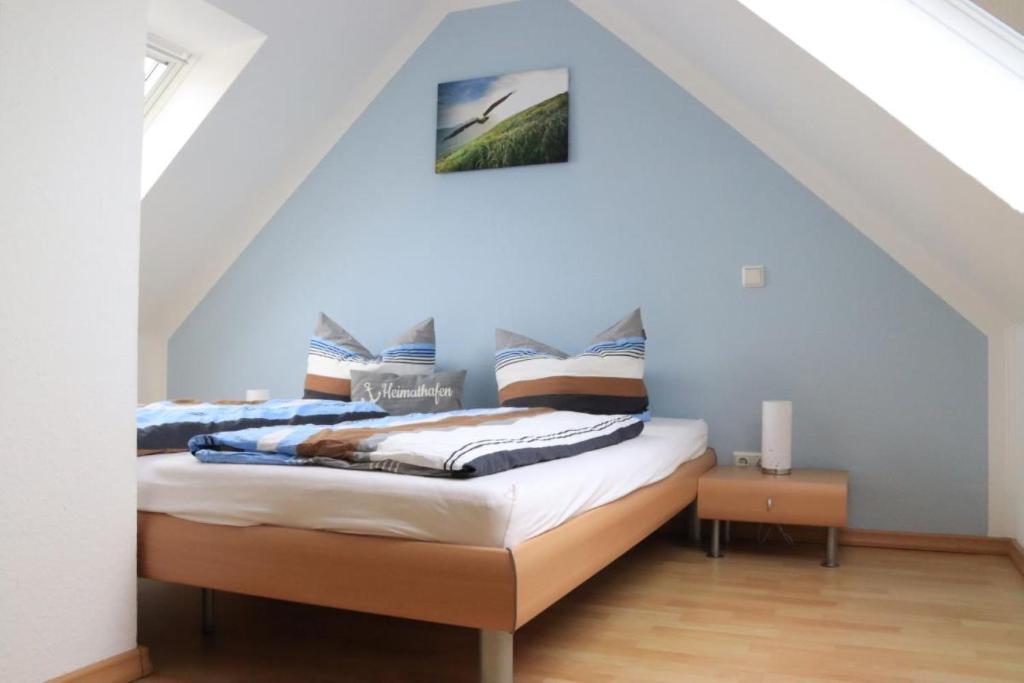 a bedroom with a bed with blue walls at Ferienwohnung mit Seeblick und Schwimmbadnutzung in Cuxhaven in Cuxhaven