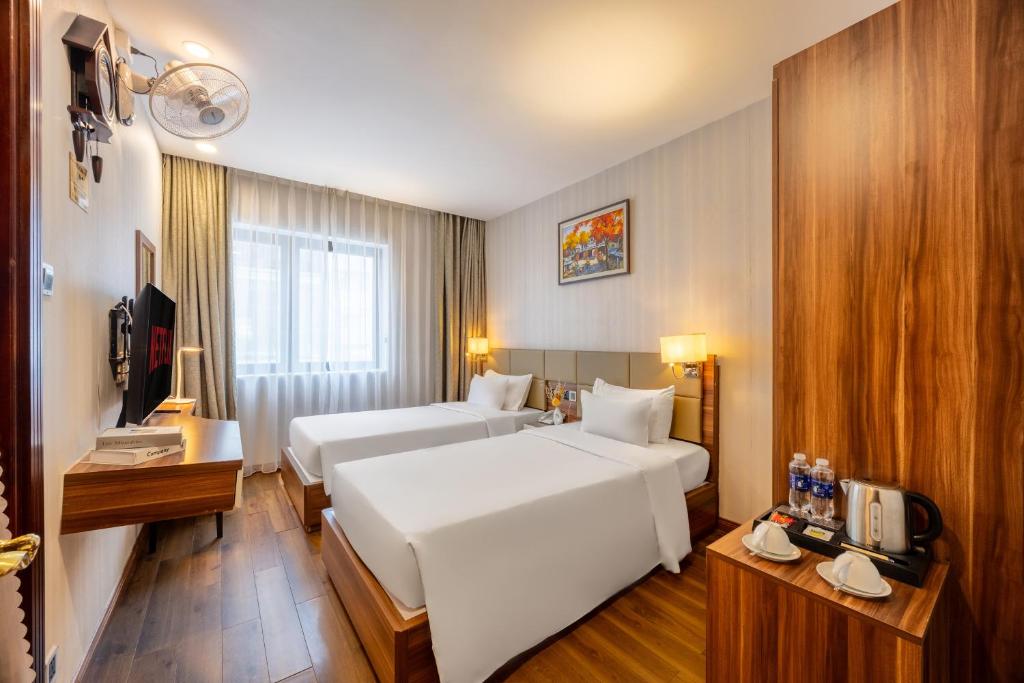 a hotel room with two beds and a television at A25 Hotel - 29 Lê Thị Hồng Gấm in Ho Chi Minh City