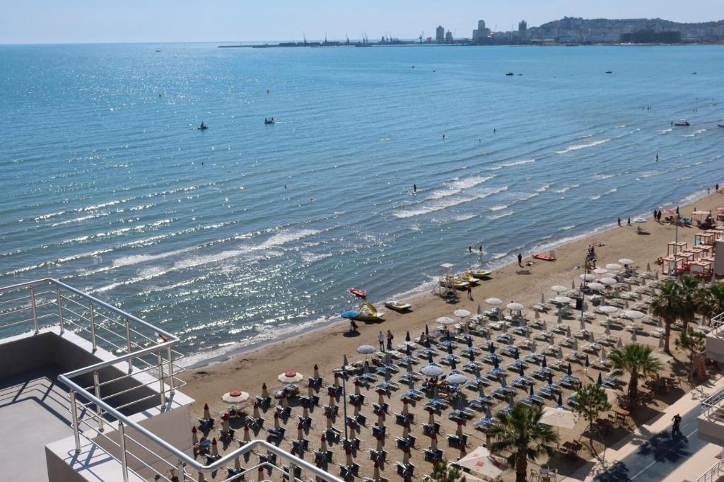a beach with chairs and umbrellas and the ocean at Sea view apartament in Durrës
