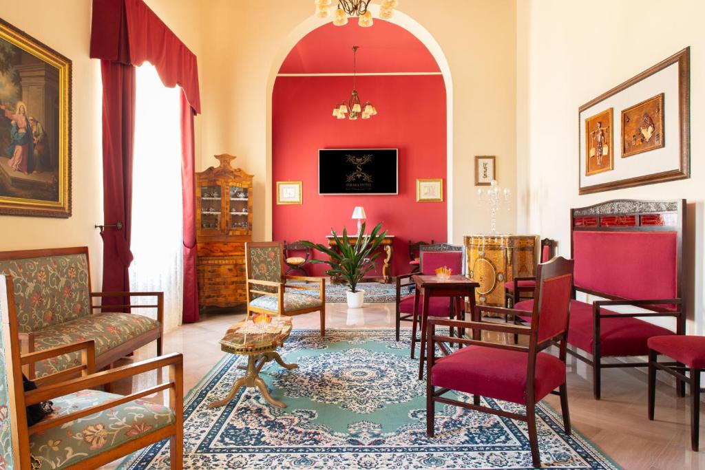 a living room with red walls and chairs at Syraka Hotel LR Collection in Syracuse