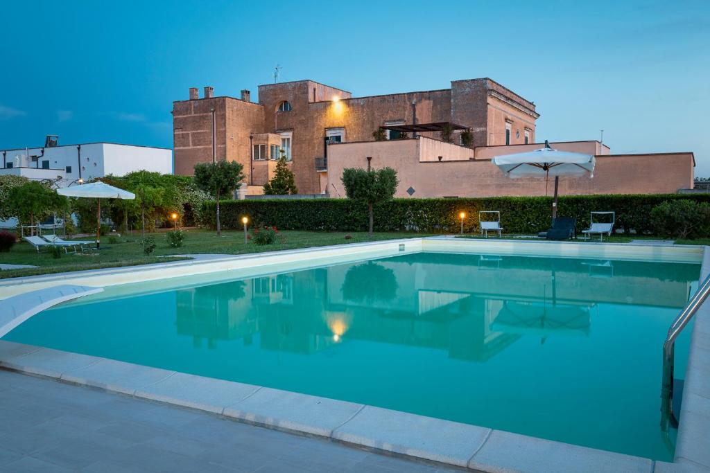 a swimming pool in front of a building at Tenuta Giardini Nuovi in Novoli