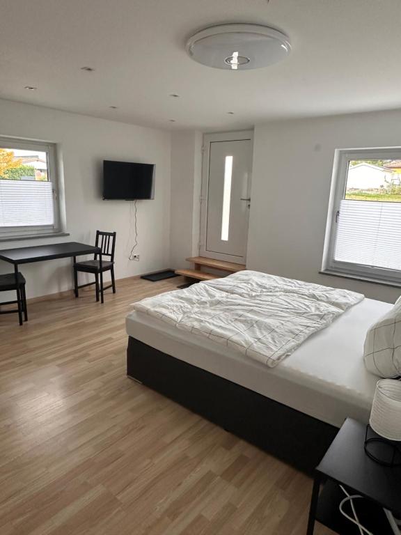 a bedroom with a bed and a desk and a television at Ferienwohnung Stefan Frank in Hengersberg
