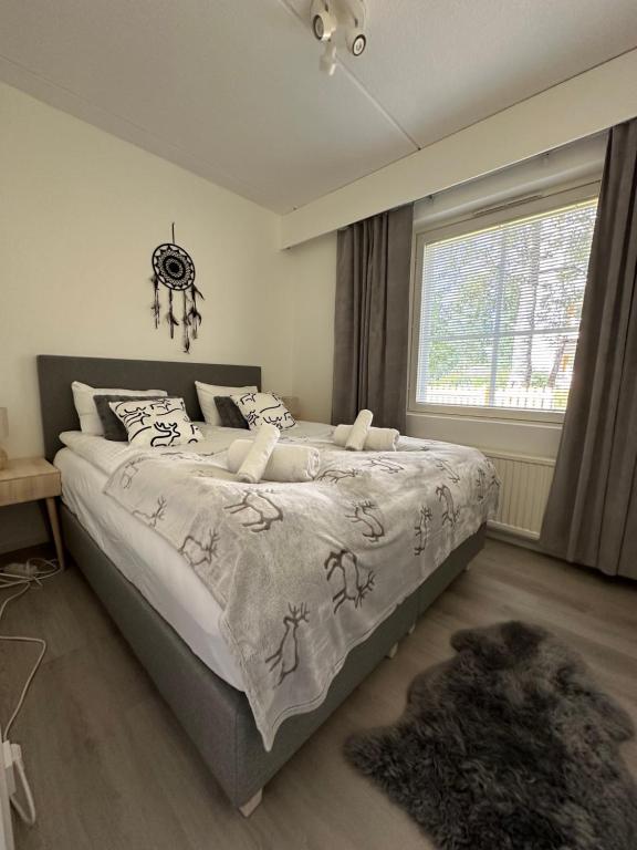 a large bed in a bedroom with a window at Apartment Ahkiomaantie in Rovaniemi