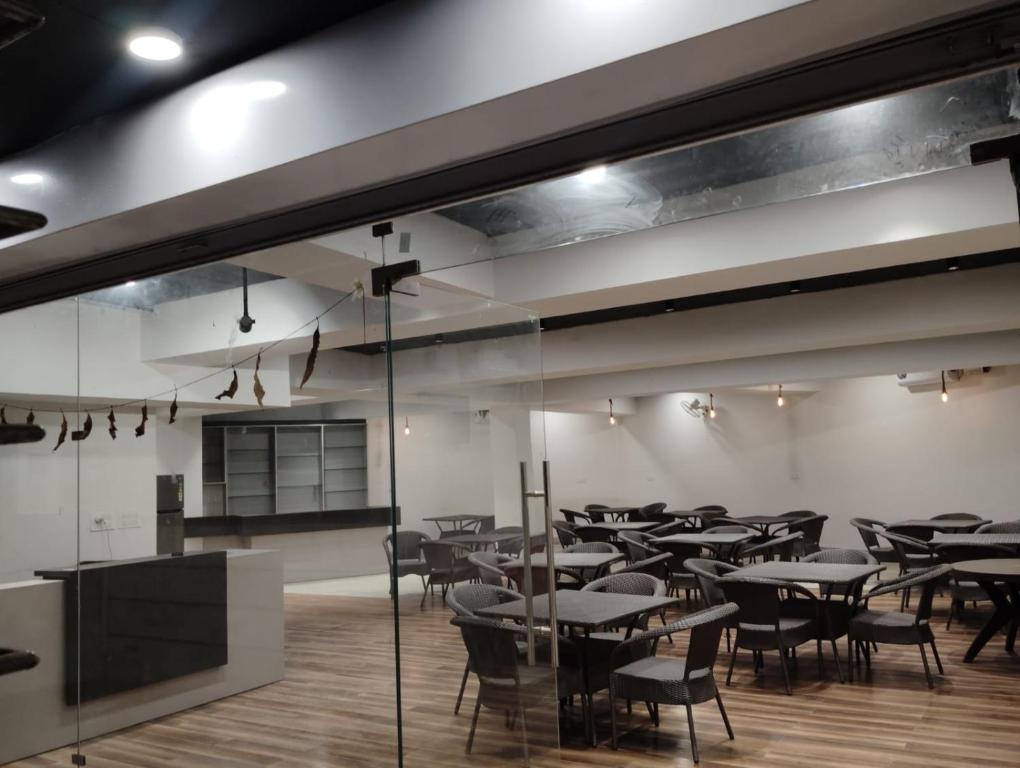 a restaurant with tables and chairs in a room at Hotel Ludhiana Residency in Ludhiana