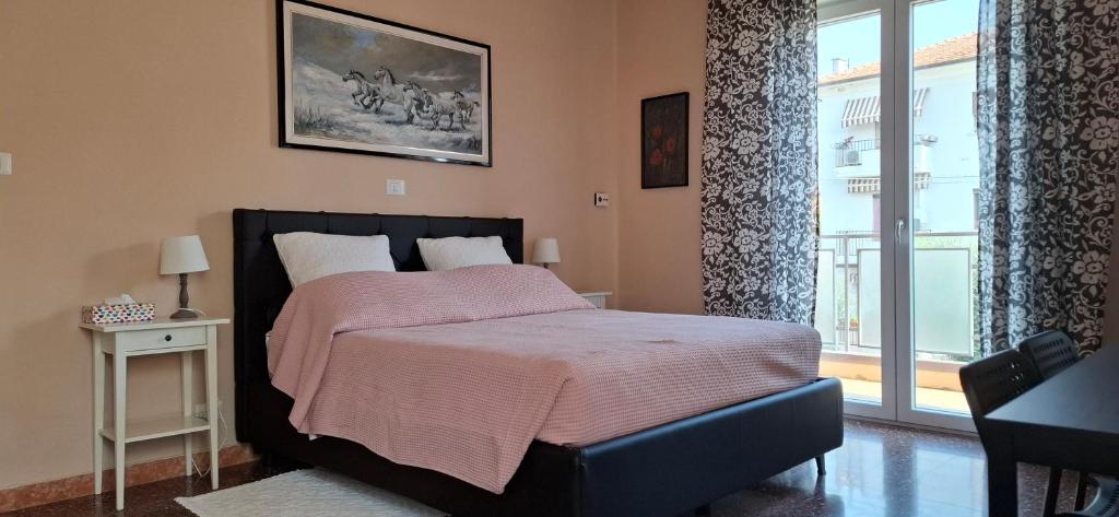 a bedroom with a bed with a pink blanket on it at Affittacamere Le Rose in Imola