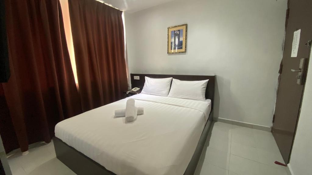 Una habitación con una cama con una cruz. en Hotel Vistana Micassa, en Taiping