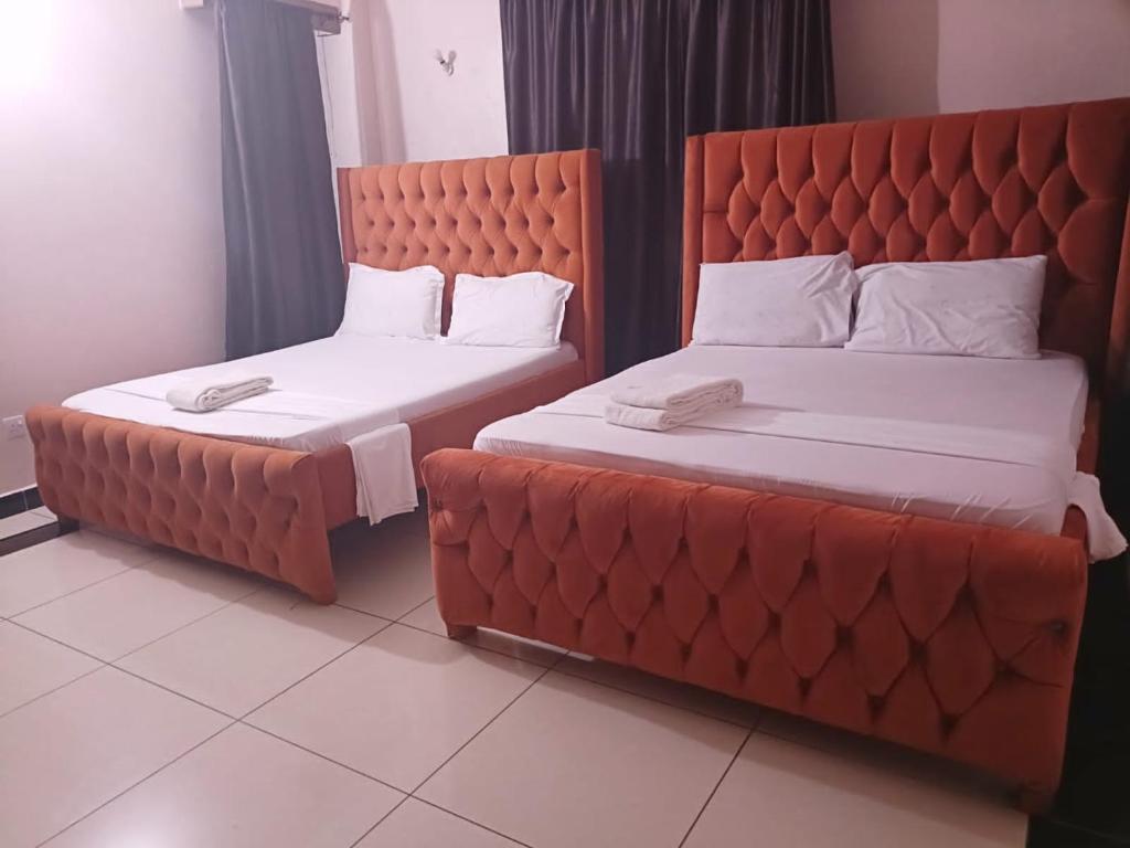Dos camas una al lado de la otra en una habitación. en Murangiri Accommodations, en Mombasa