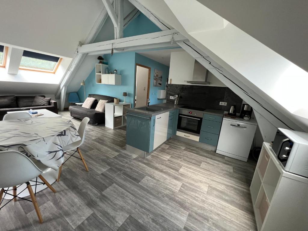 a kitchen and living room with a table and a couch at Le petit Kichon in Gérardmer