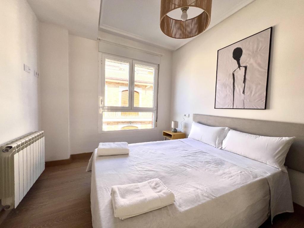 a bedroom with a large bed and a window at BaruHaus Duplex Valencia de don Juan 2 in Valencia de Don Juan