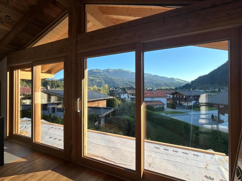 een uitzicht vanuit de woonkamer van een huis met grote ramen bij Mountainview-Lodge exklusiver Neubau mit Bergblick in Reith bei Kitzbühel