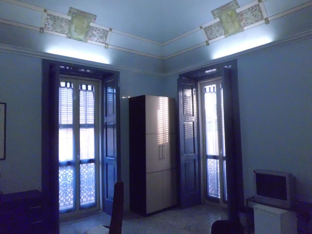 Zimmer mit zwei französischen Türen und einem TV in der Unterkunft B&B Cavour in Torre Maggiore