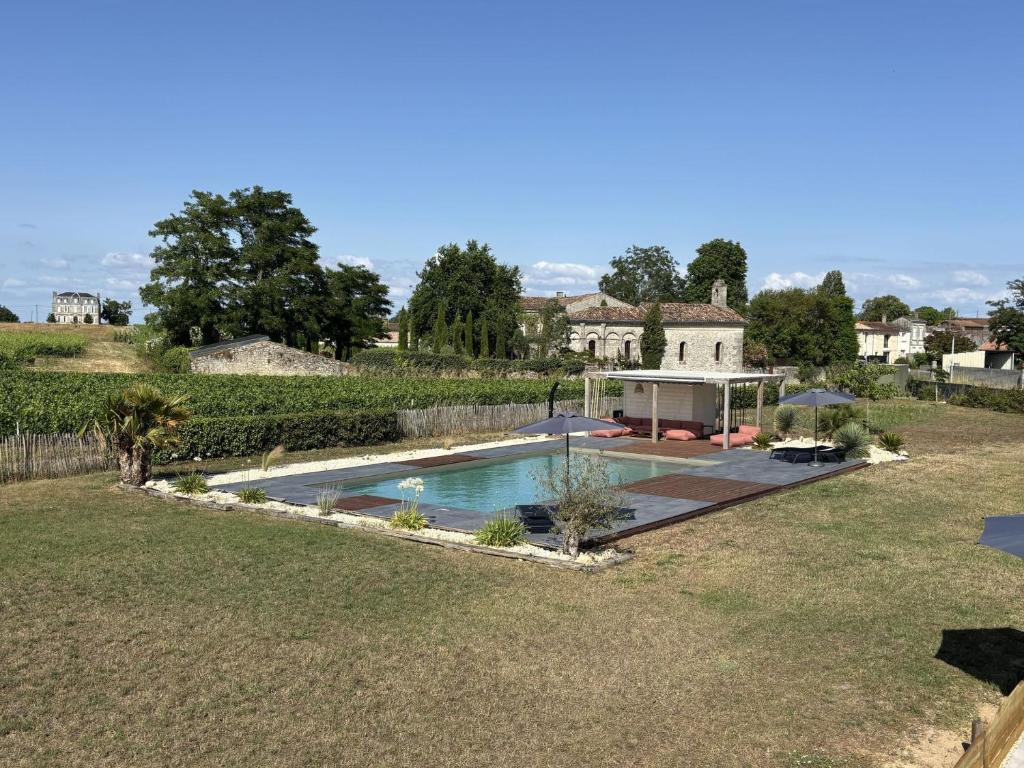 a house with a swimming pool in a yard at Les chais du Fourneau - Séjours au cœur des vignes du Médoc in Saint-Christoly-Médoc