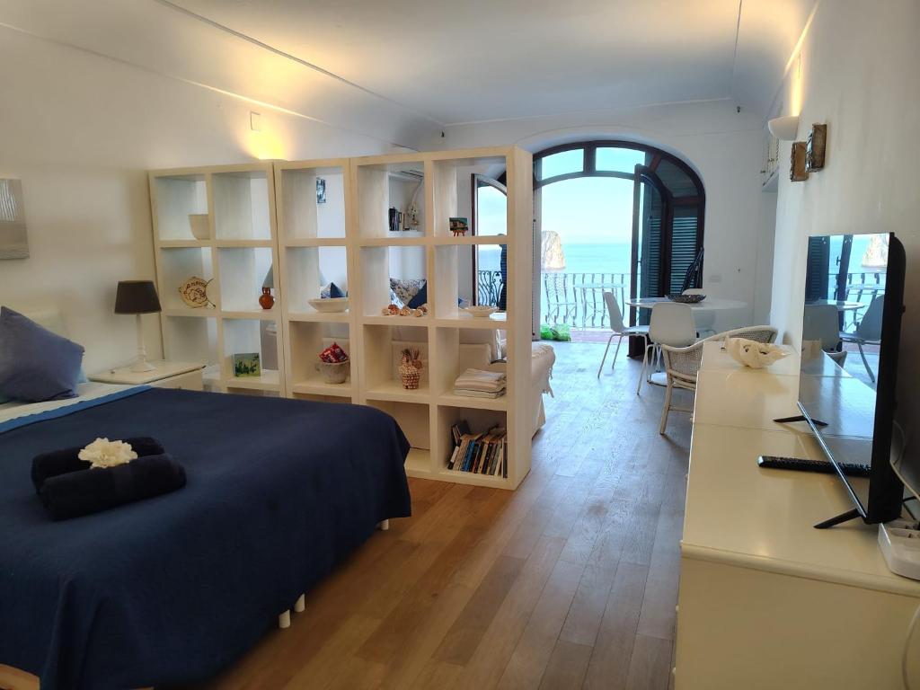 a bedroom with a bed and a desk with a television at Casa vista Faraglioni Capri in Capri