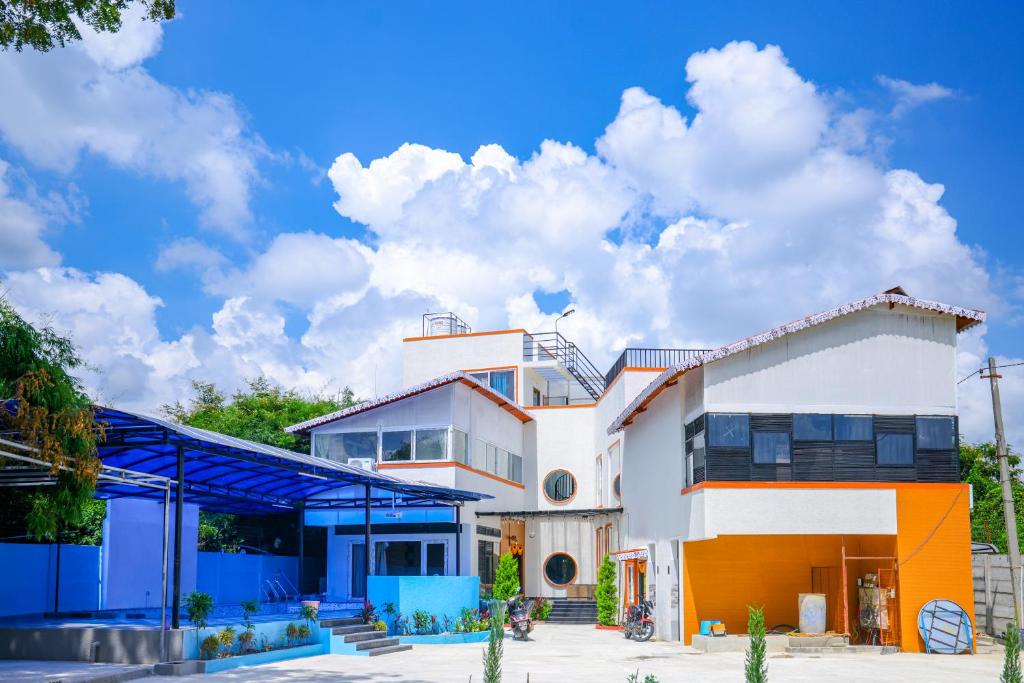 a large house with a blue roof at SPK farmhouse in Medchal