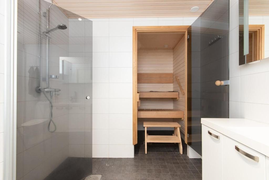 a bathroom with a shower and a toilet and a sink at Northern 2-room apartment with Sauna and Garage in Rovaniemi