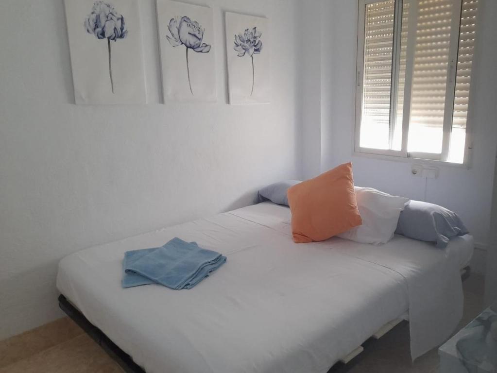 a white bed with two pillows on it in a room at A beautiful Townhouse in Rute