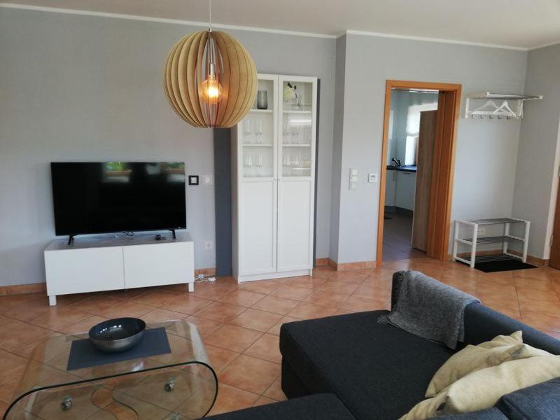 a living room with a couch and a flat screen tv at Himmelthal Apartment in Eschau