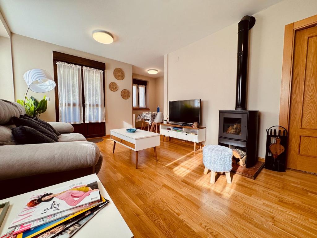 a living room with a couch and a fireplace at Apartamento Acogedor con Vistas Espectaculares en Liébana, Picos de Europa in Camaleño
