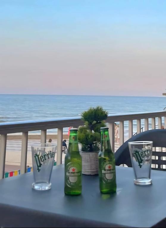 two bottles of beer sitting on a table with glasses at De frente al mar in Sueca