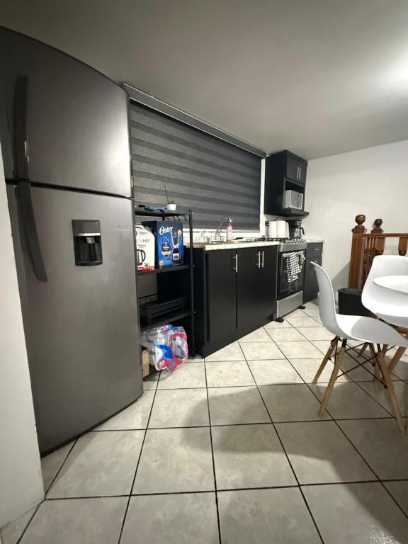 a kitchen with a stainless steel refrigerator and a table at Casa en segunda planta in Hidalgo del Parral