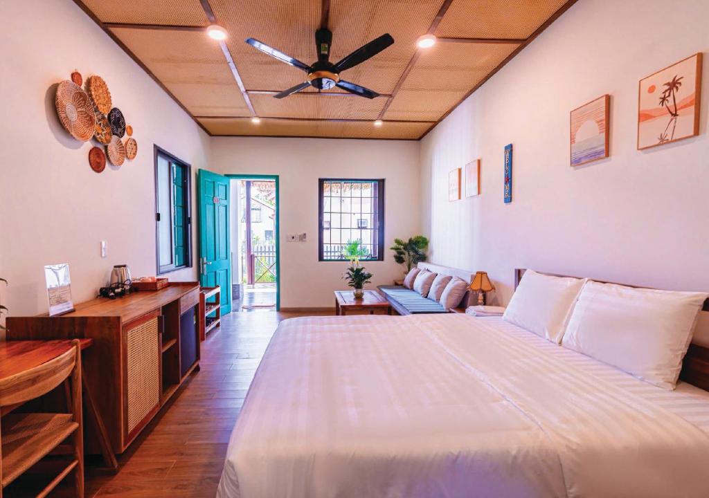 ein Schlafzimmer mit einem großen Bett und einer Couch in der Unterkunft Tropical Rustic 4BR Villa, South Phu Quoc in Phu Quoc