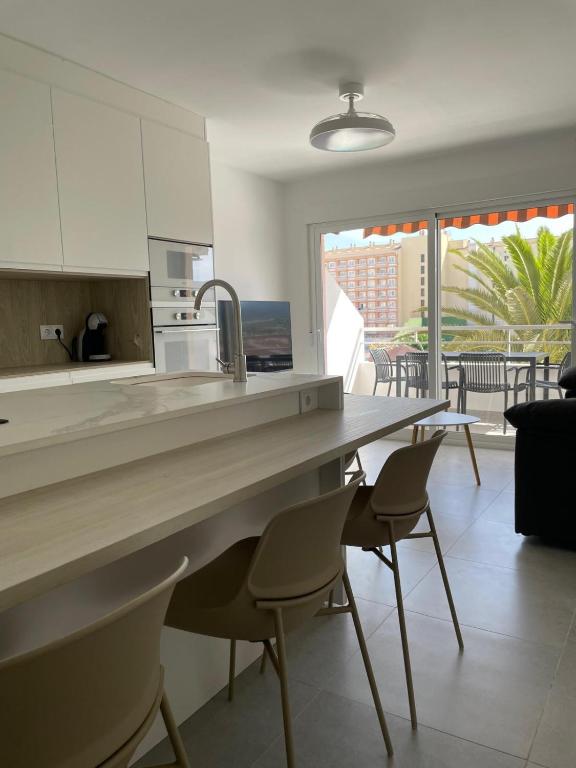 a kitchen with a table and chairs and a balcony at Penismar Paradis in Peniscola