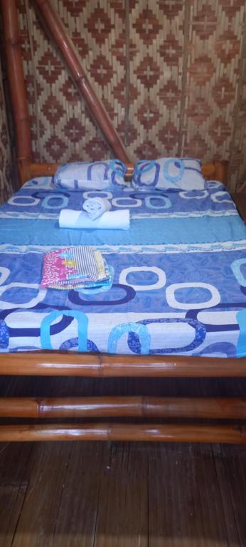 a bed with a blue blanket on top of it at Dumaguete Divers in Dauin