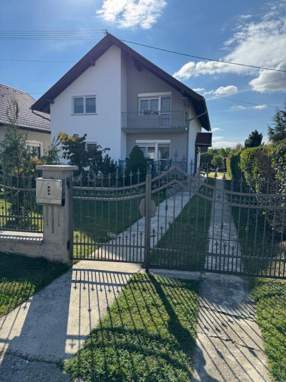 una valla delante de una casa blanca en Apartman Miškić, en Čepin