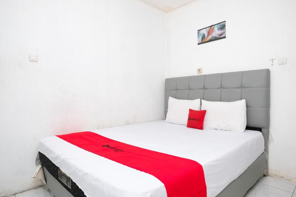 ジョグジャカルタにあるRedDoorz near Lippo Mall Yogyakarta 3の白いベッドルーム(赤い毛布付きのベッド付)