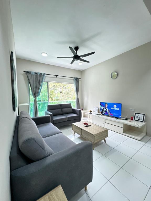 a living room with a couch and a ceiling fan at Ayaan Quintet Evergreen with FIFA & Private Parking in Tanah Rata